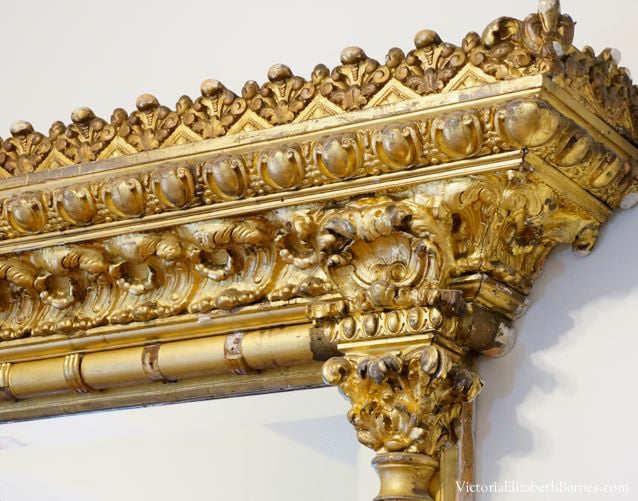 Antique mantel mirror. Large, gilded wall mirror with ornate plaster molding.