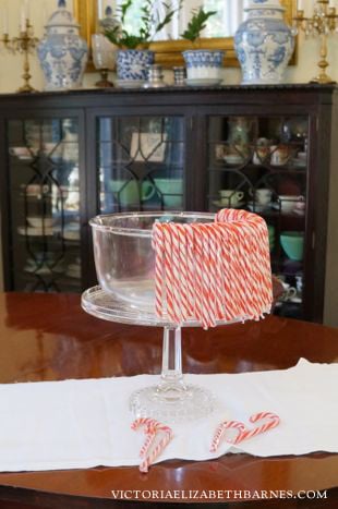 Make a candy cane centerpiece out of a cake plate. Fill it with cloved oranges or glass ornaments.